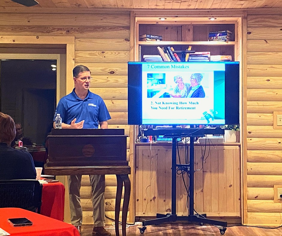A man gives a presentation on retirement planning to an audience in a wood-paneled room.
